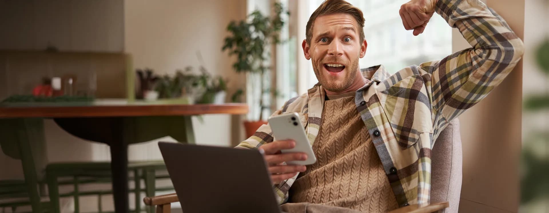 Hombre emocionado celebrando frente a su computadora